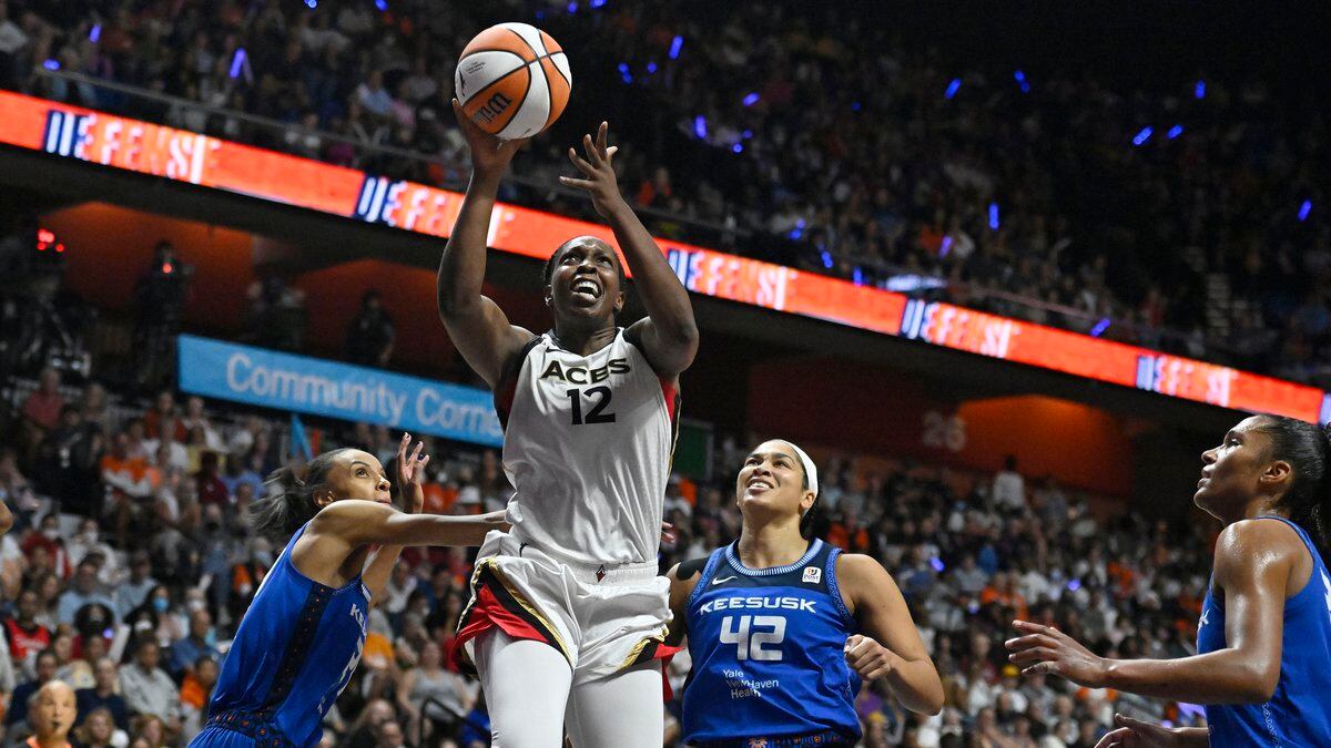 Las Vegas Aces' Chelsea Gray (12) goes up for a basket as Connecticut Sun's DeWanna Bonner,...
