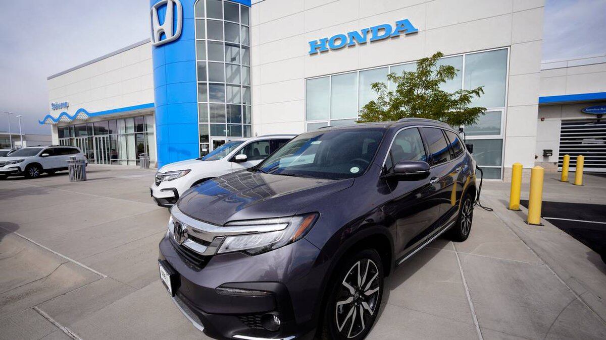FILE - A 2021 Pilot sports-utility vehicle is flanked by a 2021 CR-V as they sit on the...