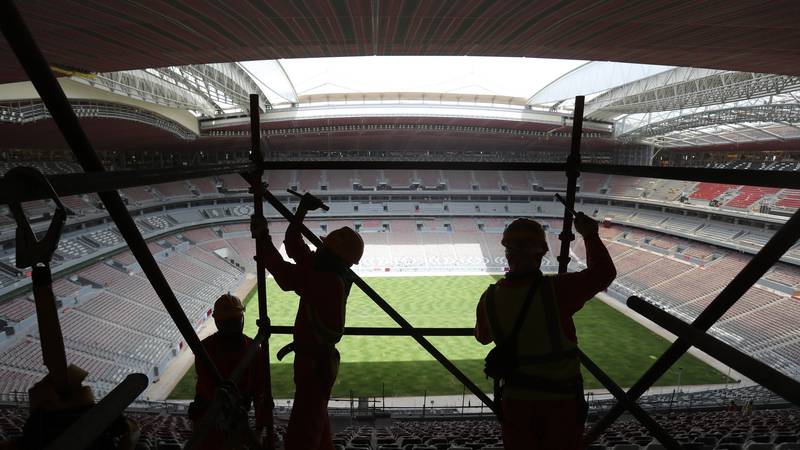 FILE - Laborers remove scaffolding at the Al Bayt stadium in Al Khor, Qatar, about 50...