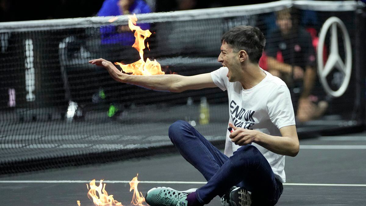 A man sets fire on his hand during protest at a match Team World's Diego Schwartzman against...