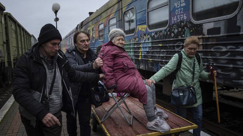 Relatives of Elizaveta, 94, transport her by a cargo cart to the evacuation train in Kherson,...