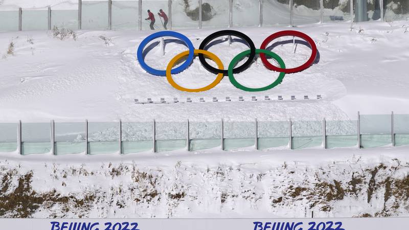 Biathletes skate above the Olympic rings during practice at the 2022 Winter Olympics, Thursday,...