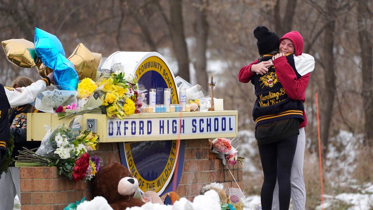 Students hug at a memorial at Oxford High School in Oxford, Mich., Wednesday, Dec. 1, 2021....