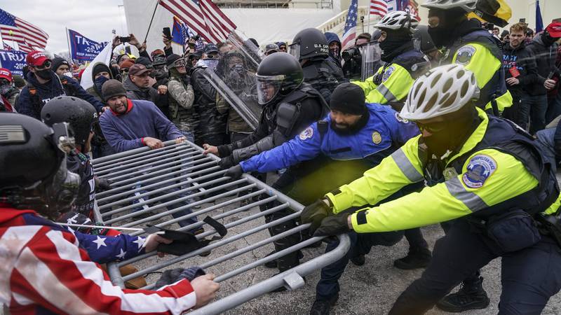 FILE - In this file photo from Wednesday, Jan. 6, 2021, Trump supporters beset a police barrier...