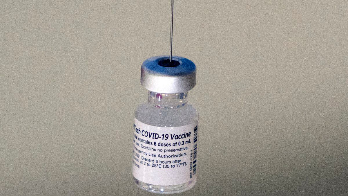 FILE - A syringe is placed into a vial of Pfizer-BioNTech vaccination at a COVID-19 clinic in...