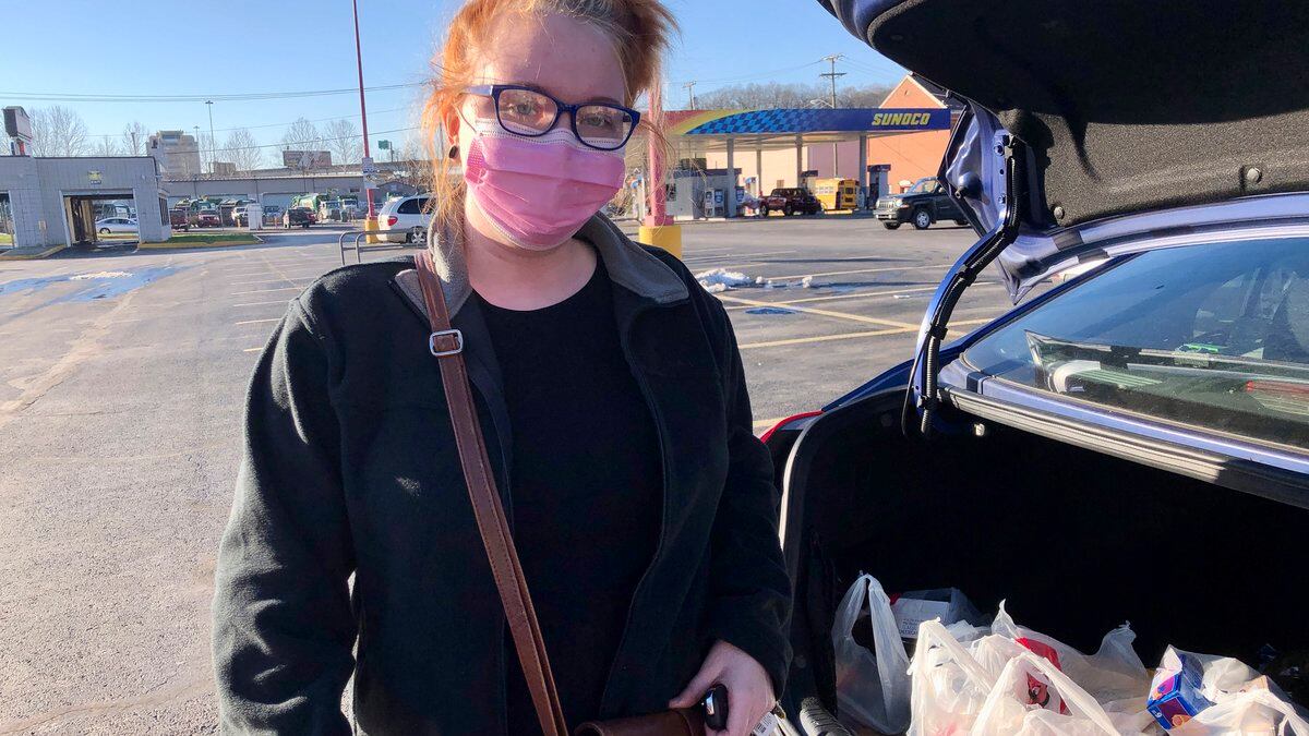 Hairdresser Chelsea Woody stands outside her car at a grocery store Tuesday, Jan. 11, 2022, in...