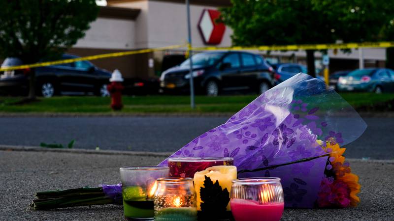 Flowers and candles lay outside the scene of a shooting at a supermarket, in Buffalo, N.Y.,...
