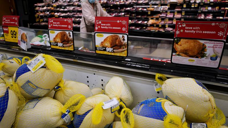 Frozen turkeys sit in a refrigerated case inside a grocery store in Mount Prospect, Ill.,...