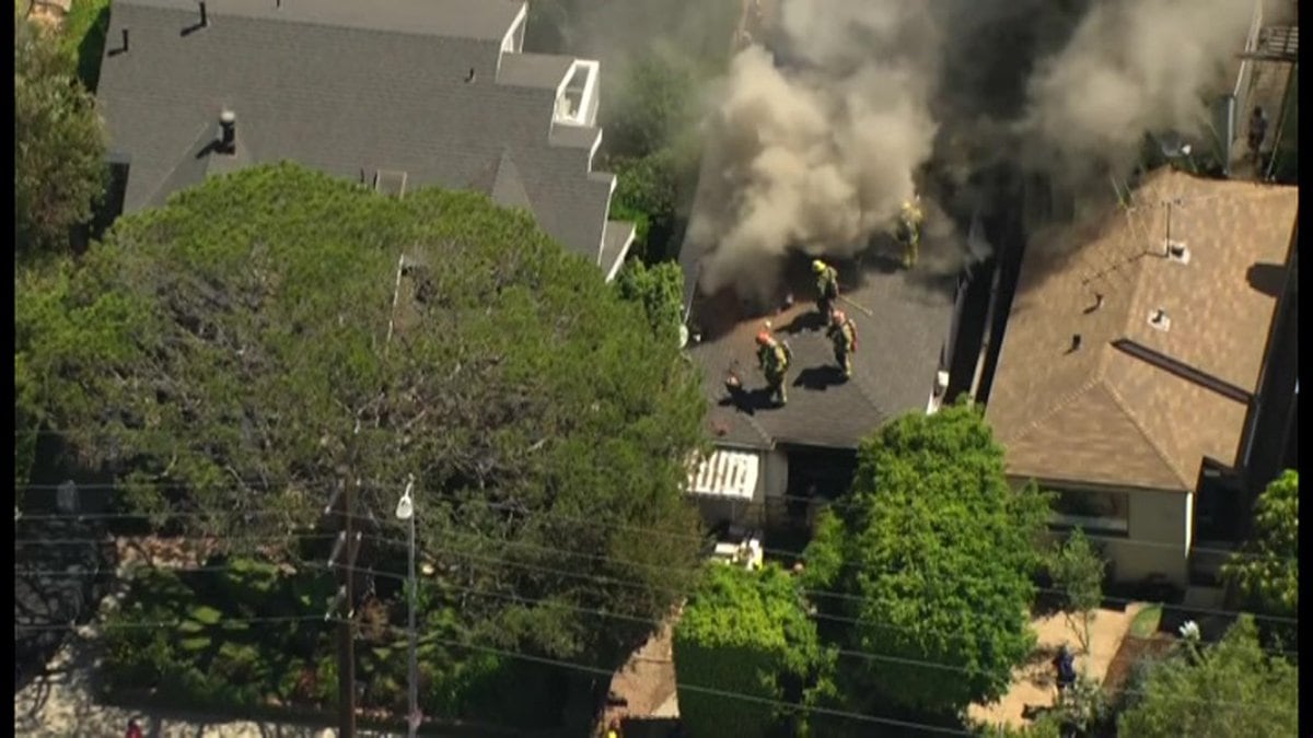 Officials say the car slammed into the two-story home, causing it to erupt into flames.