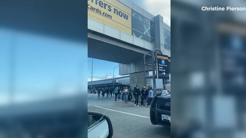 People are seen leaving a terminal at Boston's Logan International Airport on Sunday amid an...