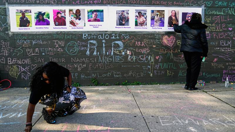 FILE - People pay their respects at a makeshift memorial near the scene of a mass shooting at a...
