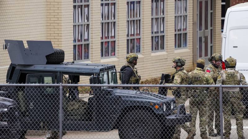 Law enforcement teams stage near Congregation Beth Israel while conducting SWAT operations in...