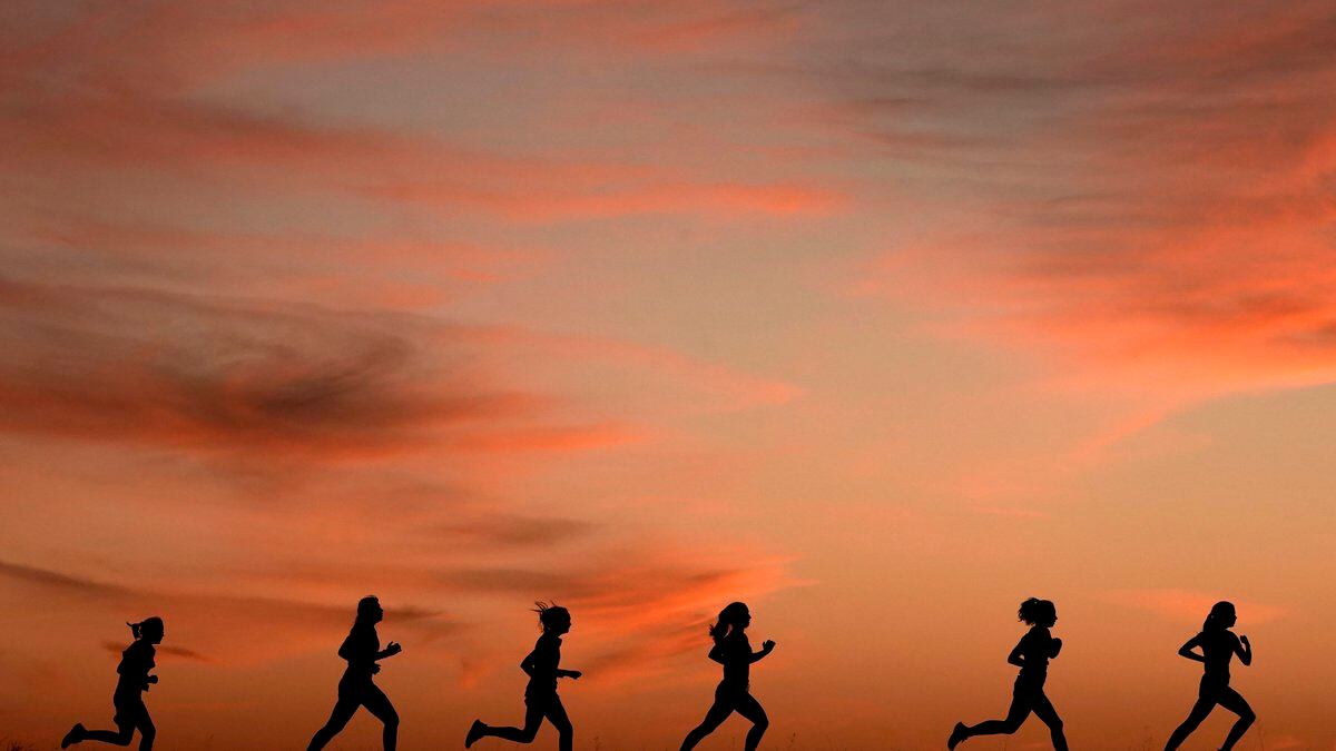 High school students run at sunset as they practice for the track and field season Monday, Feb....