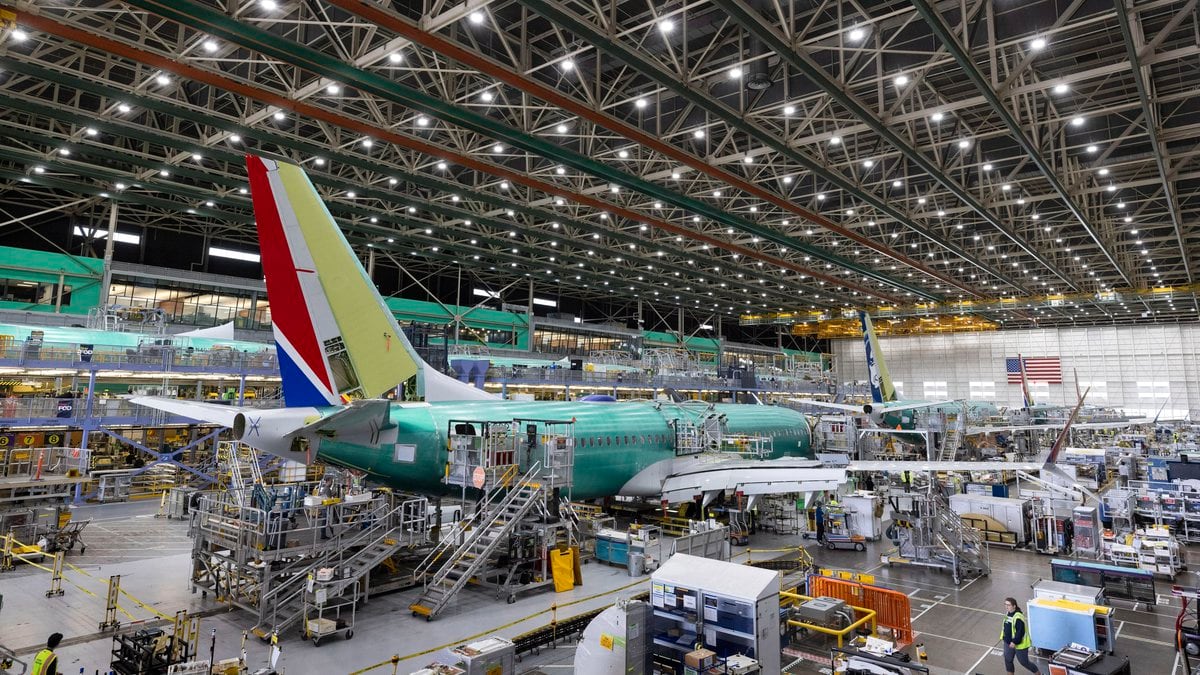 FILE - Boeing employees work on a 737 Max on the final assembly line at Boeing's Renton plant,...
