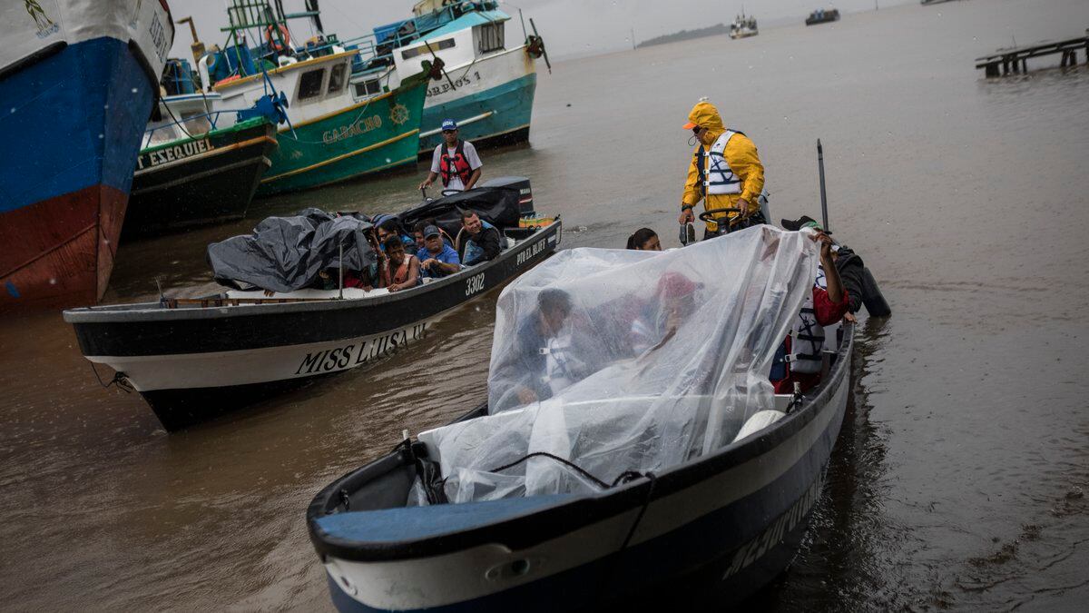 People leave the port by boat to return their communities amid the arrival of Tropical Storm...