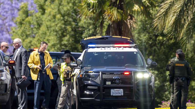 Investigators gather outside the Geneva Presbyterian Church in Laguna Woods, Calif., on Sunday,...