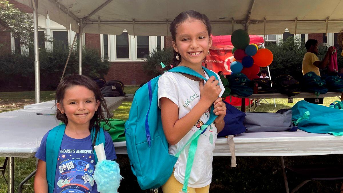 From left, sisters Audrey and Jubilee Colon pick out new backpacks at a Chicago Public Schools...