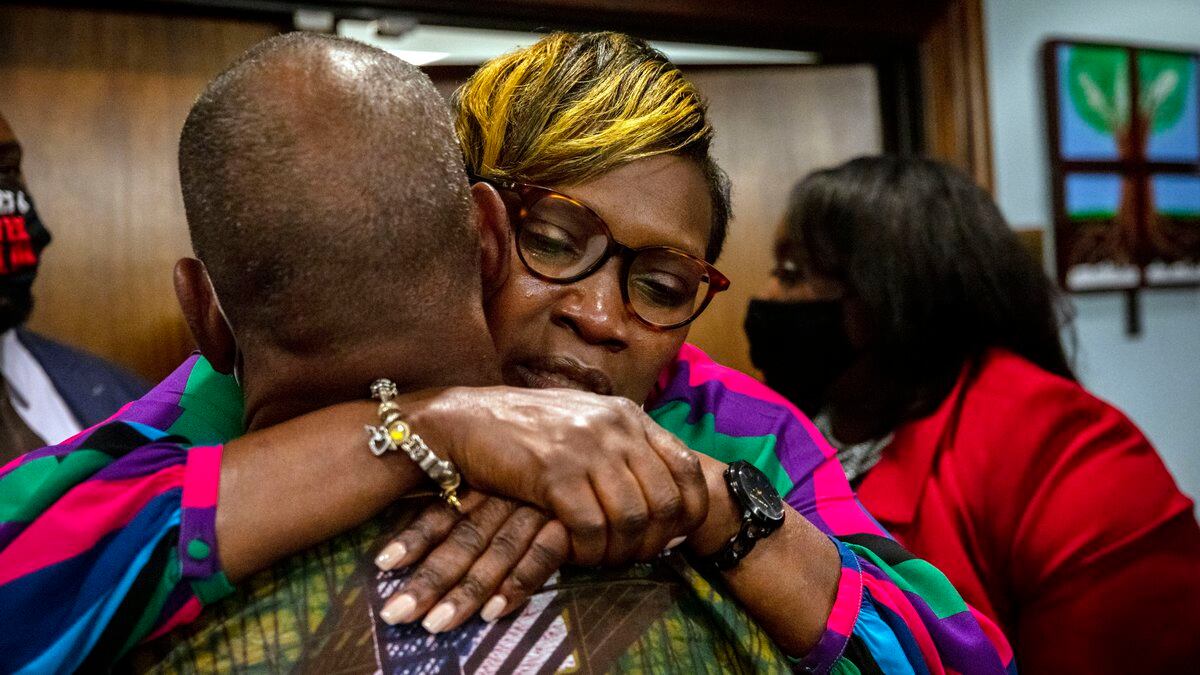 Ahmaud Arbery's mother, Wanda Cooper-Jones, is hugged by a supporter after the jury convicted...