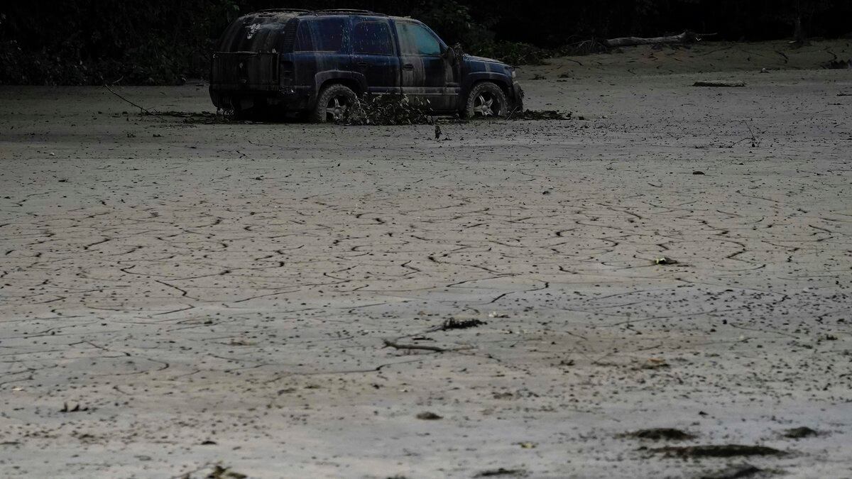 A vehicle is abandoned and surrounded by mud caused by massive flooding on Friday, Aug. 5,...