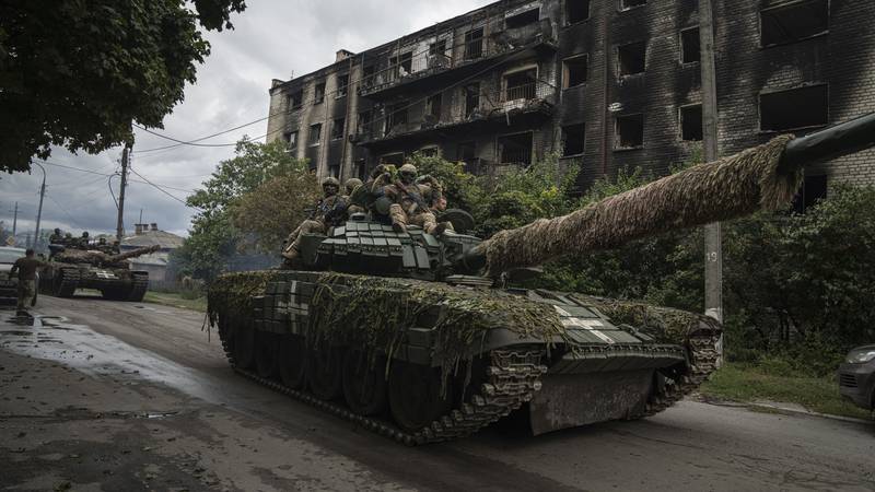 Ukrainian servicemen ride on a tank in the recently retaken area of Izium, Ukraine, Wednesday,...