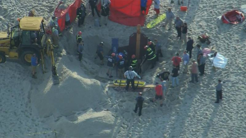 Authorities in New Jersey attempt to rescue two siblings who got trapped in sand after digging...