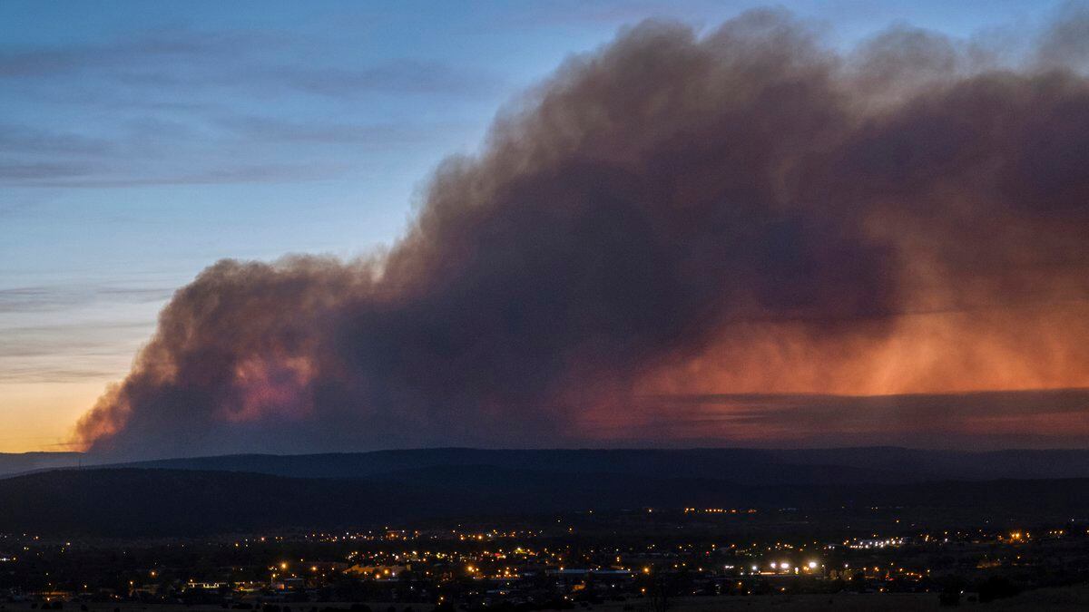 FILE - Smoke from the Calf Canyon/Hermit Peak Fire drifts over Las Vegas, N.M., on May 7, 2022.