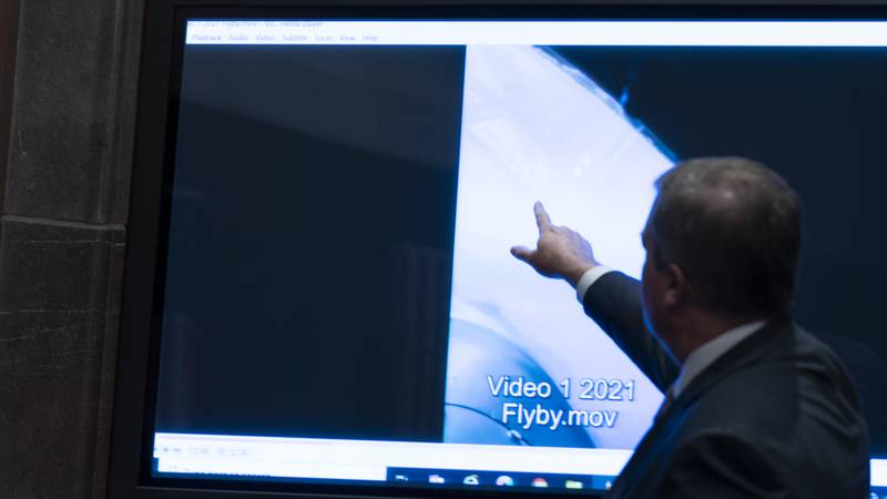 Deputy Director of Naval Intelligence Scott Bray points to a video display of a UAP during a...