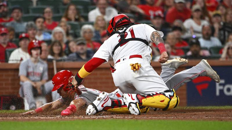 Cincinnati Reds' Stuart Fairchild, left, is tagged out at home plate by St. Louis Cardinals...