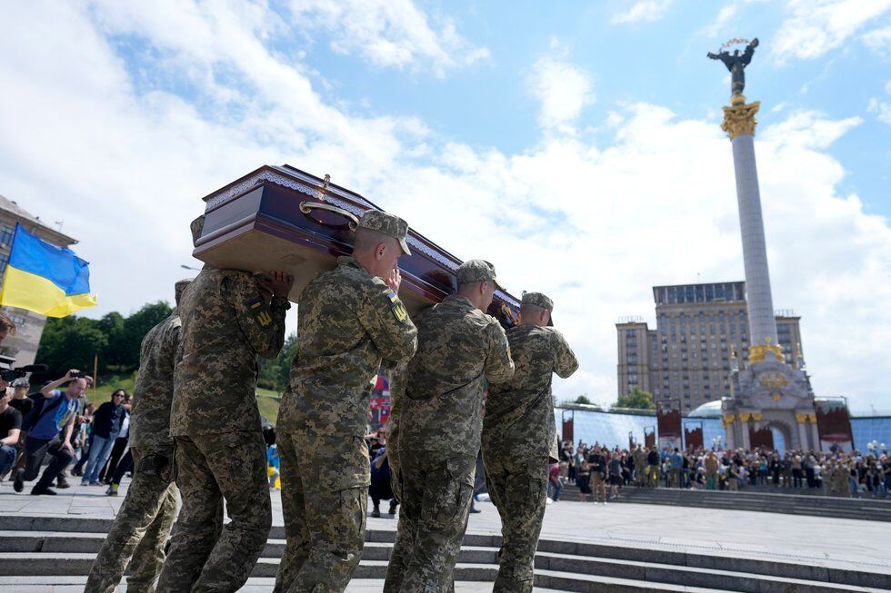 Soldiers carry the coffin of activist and soldier Roman Ratushnyi for a memorial service at...