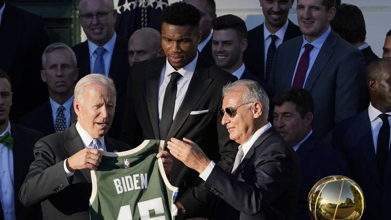 President Joe Biden holds a jersey presented to him by owner Marc Lasry during an event to...