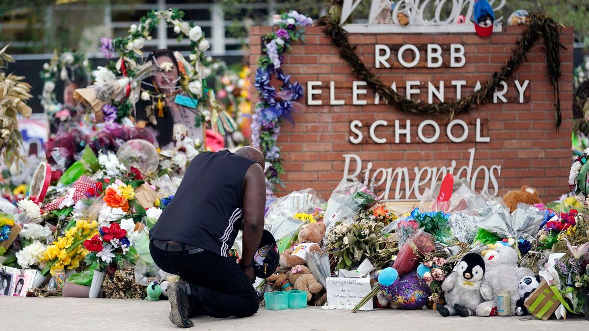 FILE - Reggie Daniels pays his respects at a memorial at Robb Elementary School in Uvalde,...