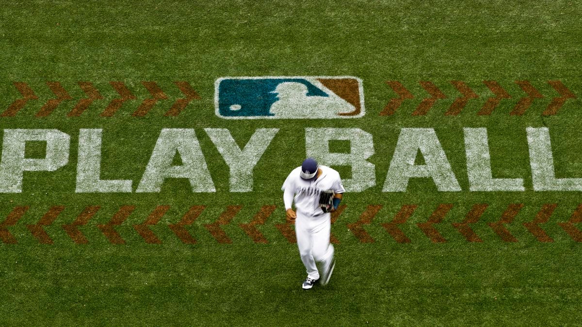 FILE - San Diego Padres left fielder Allen Cordoba passes a logo for Play Ball, an initiative...