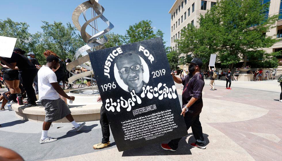 FILE - In this June 27, 2020 file photo, demonstrators carry a giant placard during a rally and...
