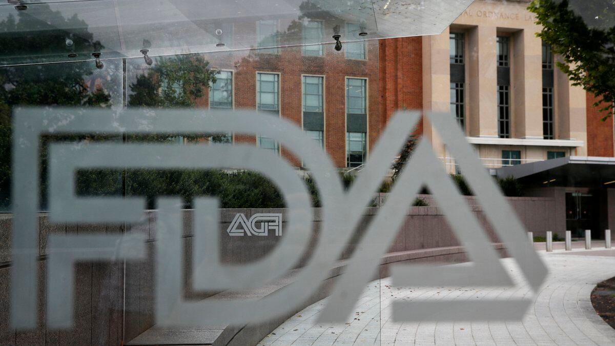 FILE - The U.S. Food and Drug Administration building stands behind an FDA logo at a bus stop...