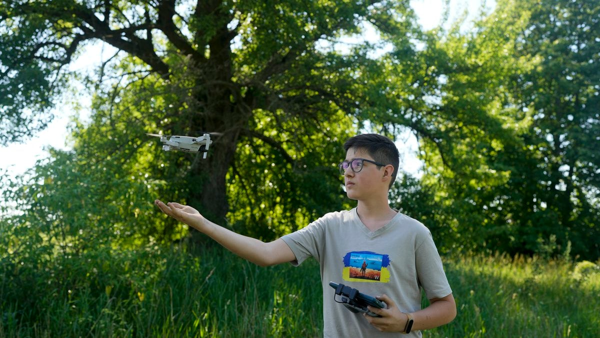 Andriy Pokrasa, 15, lands his drone on his hand during an interview with The Associated Press...