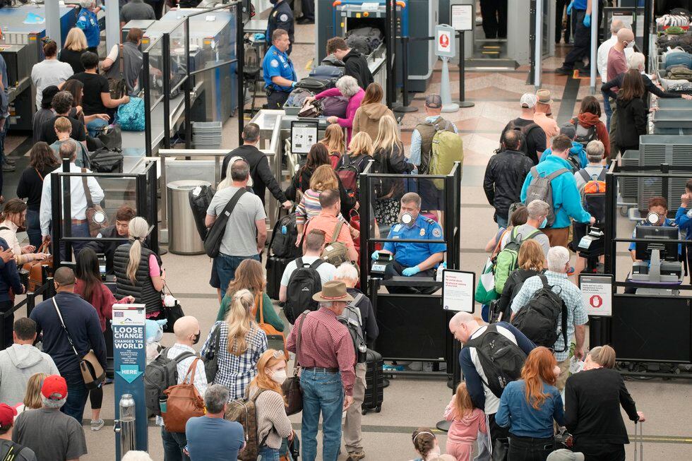 FILE - Travelers queue up move through the north security checkpoint in the main terminal of...
