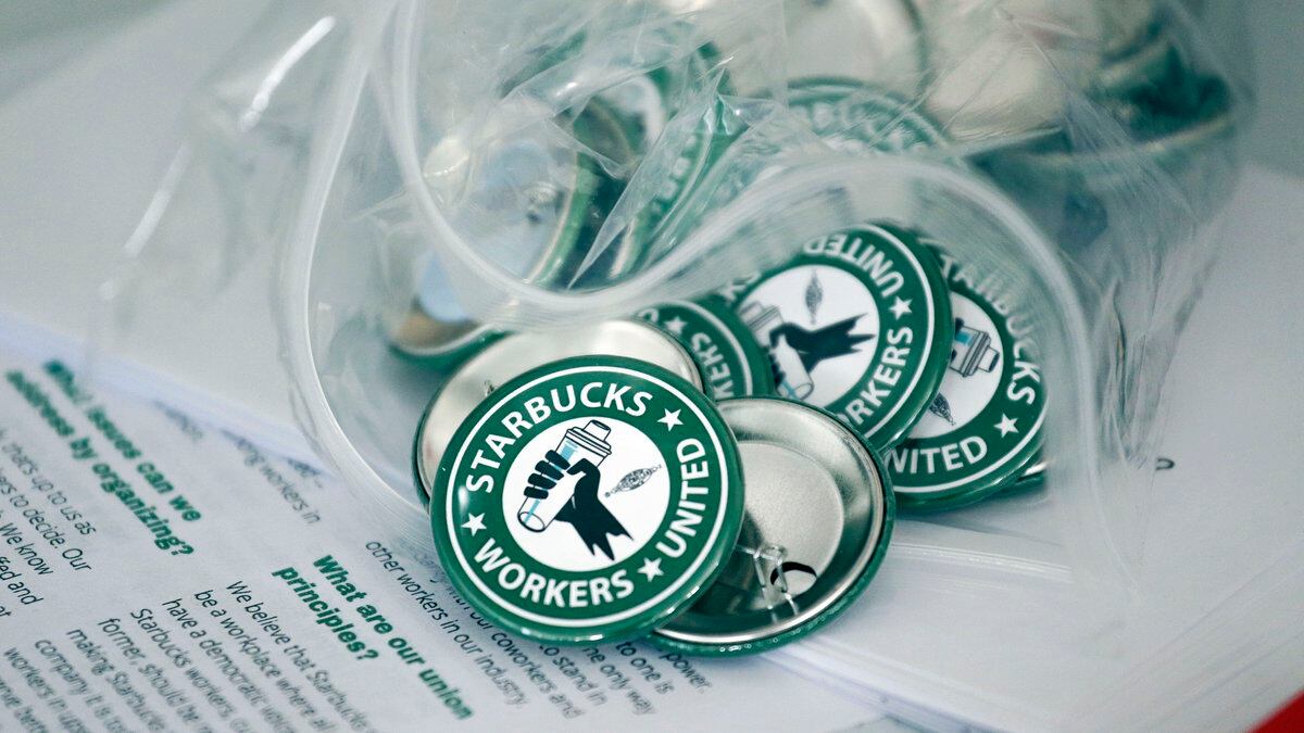 FILE - Pro-union pins sit on a table during a watch party for Starbucks' employees union...