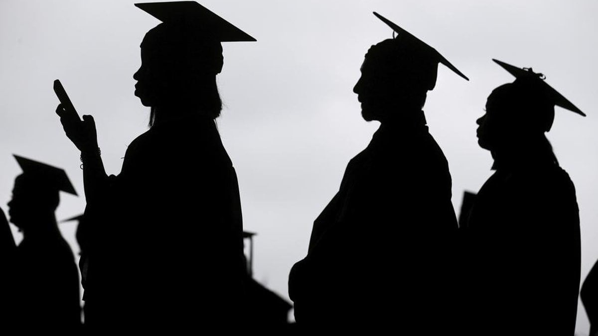 FILE - New graduates line up before the start of a community college commencement in East...