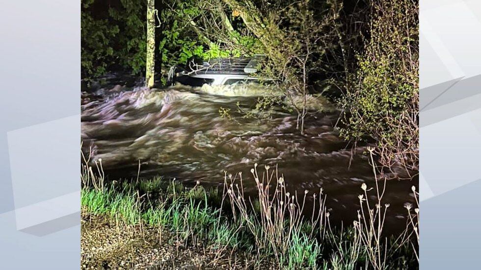 An Oconto County Sheriff's Office SUV is swept into the brush by floodwater after a section of...