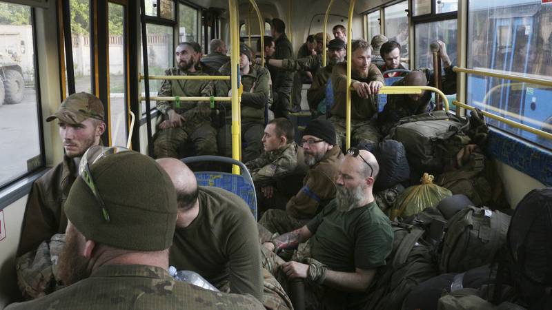 Ukrainian servicemen sit in a bus after they were evacuated from the besieged Mariupol's...