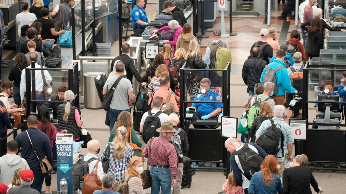FILE - Travelers move through the north security checkpoint in the main terminal of Denver...