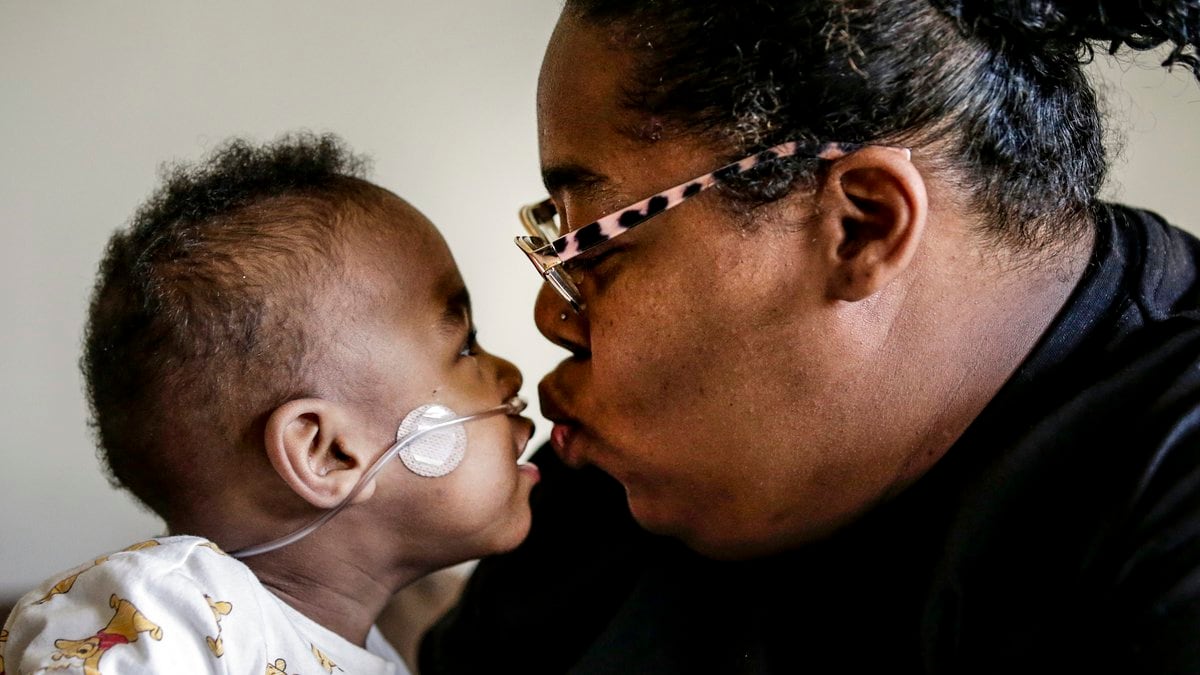 Curtis Means kisses his mother, Michelle Butler at their home in Eutaw, Ala., on Wednesday,...