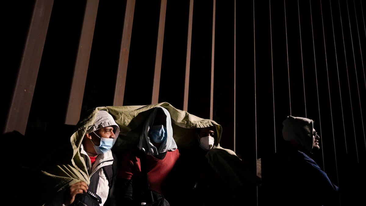 FILE - Four men from Cuba try to keep warm after crossing the border from Mexico and...